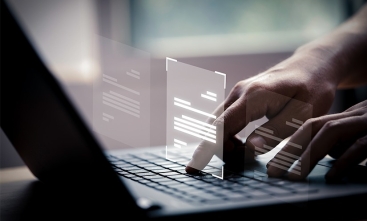Fotografia ilustrativa de mãos digitando no teclado de um notebook