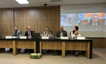 Cinco pessoas sentadas em uma mesa de palestras