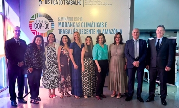 Fotografia com 3 homens e 7 mulheres vestidos formalmente e sorrindo para a câmera
