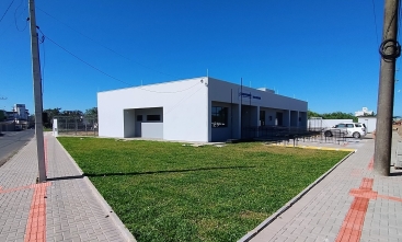 Imóvel de um pavimento, pintado em concreto, em visão diagonal, com um gramado à frente.