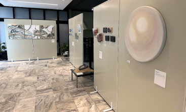 Foto de uma exposição com obras de arte expostas em painéis