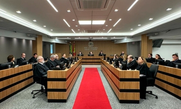 Fotografia do plenário do TRT-SC com magistrados sentados em U, diante da mesa da Presidência, e tapete vermelho ao centro