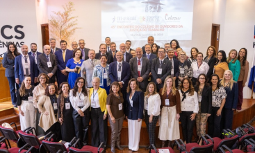 Grupo grande de participantes posa sorrindo em auditório durante o 45º Encontro do Coleouv