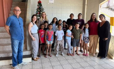 Grupo de crianças com alguns adultos posam para a foto