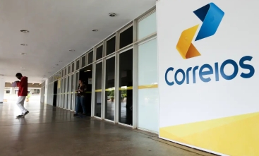 Fotografia da entrada de agência dos Correios com logo grande à direita