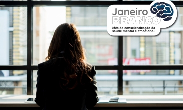 Mulher sentada de costas, olhando pela janela. Texto: “Janeiro Branco, saúde mental e emocional”.