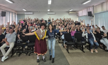 Foto de um auditório cheio de trabalhadores homens e mulheres celebrando.