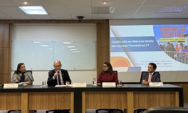 Dois homens e duas mulheres sentados à mesa de um evento