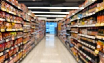 Fotografia ilustrativa de um corredor de supermercado, com os produtos à mostra nas gôndolas