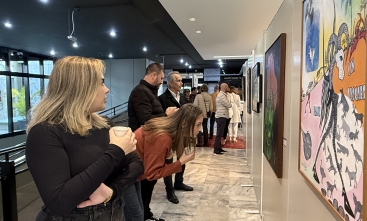 Grupo de oito pessoas observando telas de Franklin Cascaes