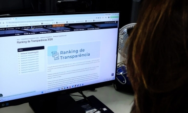 Fotografia de pessoa de frente a uma tela de computador aberta na página do Ranking de Transparência