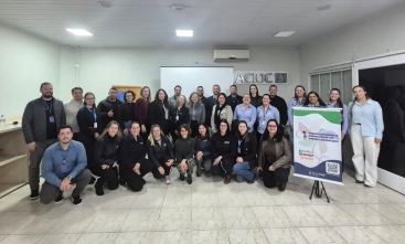 Grupo de 30 pessoas reunidas posam para foto na sede da ACIOC