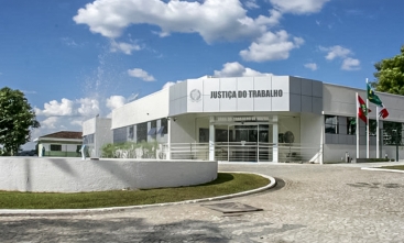 Foto da fachada da Vara do Trabalho de Mafra, com um chafariz à frente.