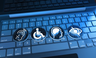 Teclas de um notebook com quatro símbolos de acessibilidade: audição, mobilidade, deficiência intelectual e deficiência visual.