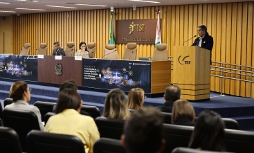 Seminário no TST, com palestrante em um púlpito e participantes sentados no auditório.