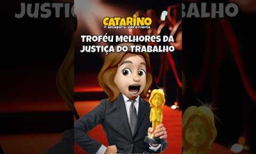 Arte com fundo de tapete vermelho de premiação. Um personagem em estilo avatar, de terno, aparece segurando um troféu dourado. No topo está o título “Catarino – o estagiário sobrevivente” e, ao centro, o texto “Troféu Melhores da Justiça do Trabalho