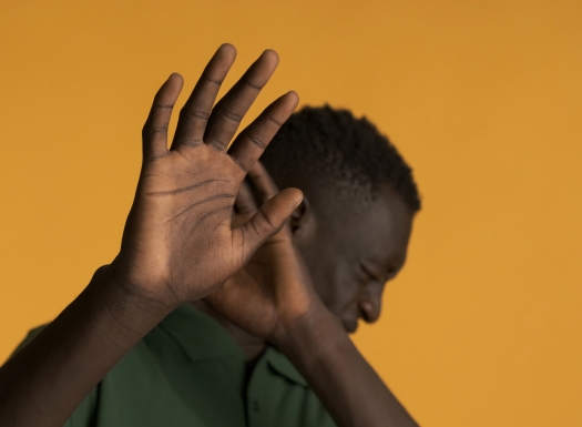 Foto de um homem negro mostrando a palma da mão