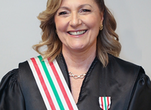 Foto de uma mulher branca vestida de beca e uma medalha no peito