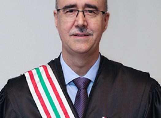 Foto de um homem branco vestido de beca e uma medalha no peito