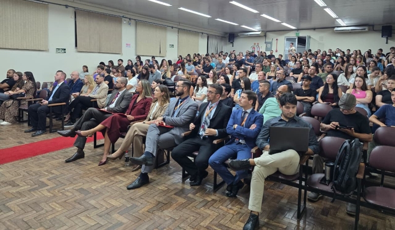 Cerca de 300 pessoas assistem a uma apresentação em um auditório