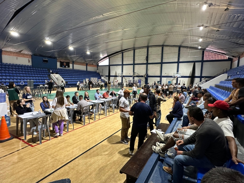 Imagem de uma quadra de um ginásio com um evento acontecendo