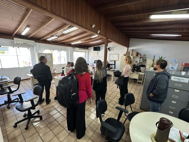 Fotografia em que pessoas de costas observam sala de atendimento