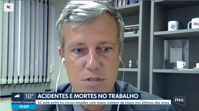 Imagem de um homem grisalho, com fones de ouvido, concedendo entrevista online