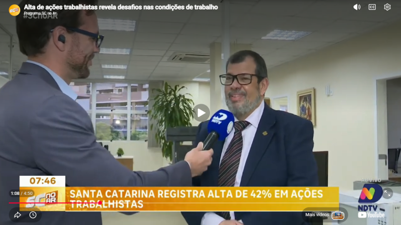 Imagem de um homem de gravata falando a um repórter 