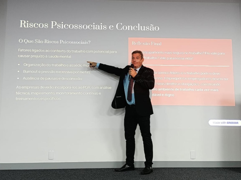 Foto de um homem de terno e gravata fazendo uma palestra