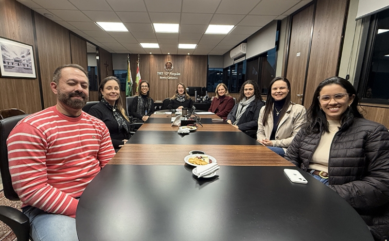 Grupo de pessoas sentadas ao redor de uma mesa