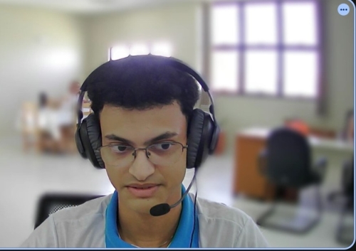 Captura de tela de um jovem negro, de óculos, usando microfone headset