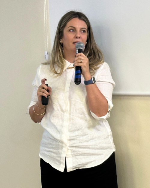 Foto de uma mulher loira falando no microfone