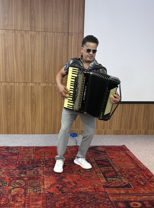 Homem de óculos toca acordeon