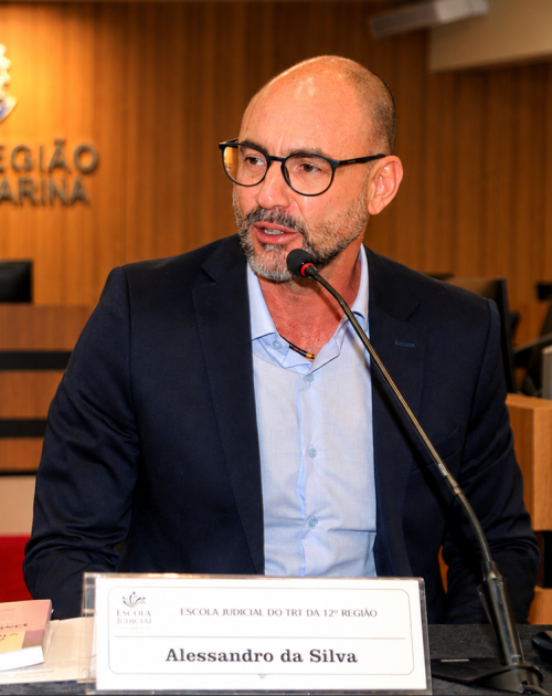 Homem de óculos fala ao microfone