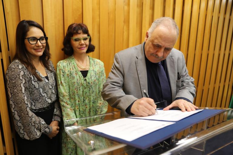 Na foto, o corregedor José Ernesto Manzi assina o convênio. Ele está sendo observado pelas presidentes dos TRTs de MT e SC, desembargadoras Eliney Veloso e Mari Eleda, respectivamente