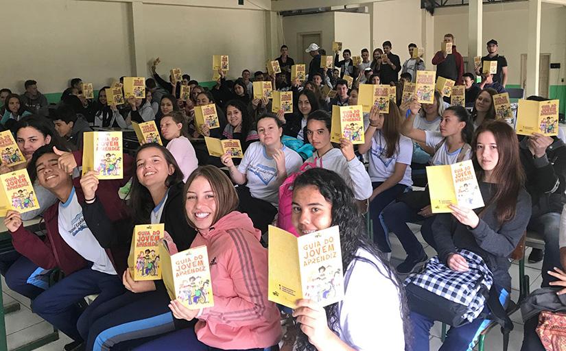 Dezenas de alunos com as cartilhas Trabalho infantil não é brinquedo! em mãos
