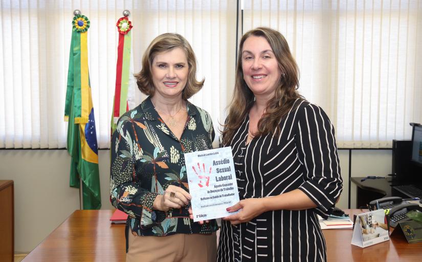Presidente Lourdes Leiria entregando livro à vice-presidente e diretora da Escola Judicial Teresa Cotosky