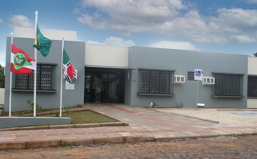 Fachada da Vara do Trabalho de Xanxerê, com bandeiras do Estado de Santa Catarina, do Brasil e do município à esquerda da imagem