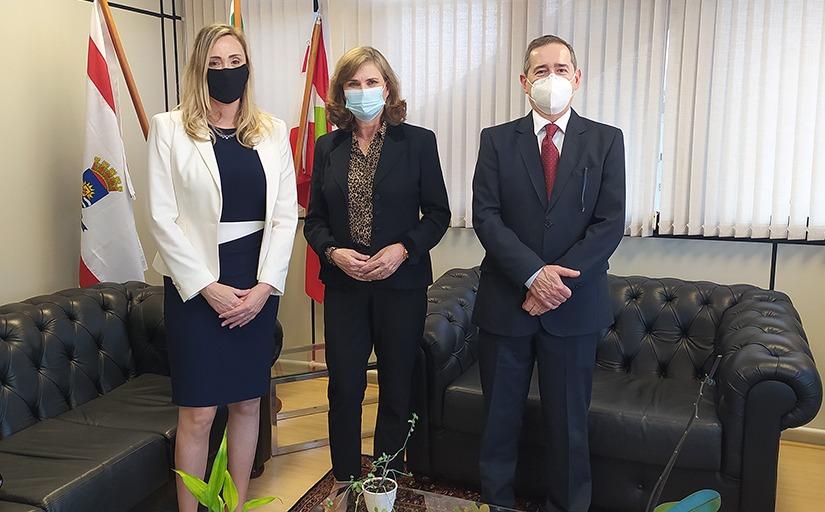 Dirigentes de pé, um ao lado do outro, em foto posada registrada no Gabinete da Presidência do TRT-SC, com bandeiras ao fundo.