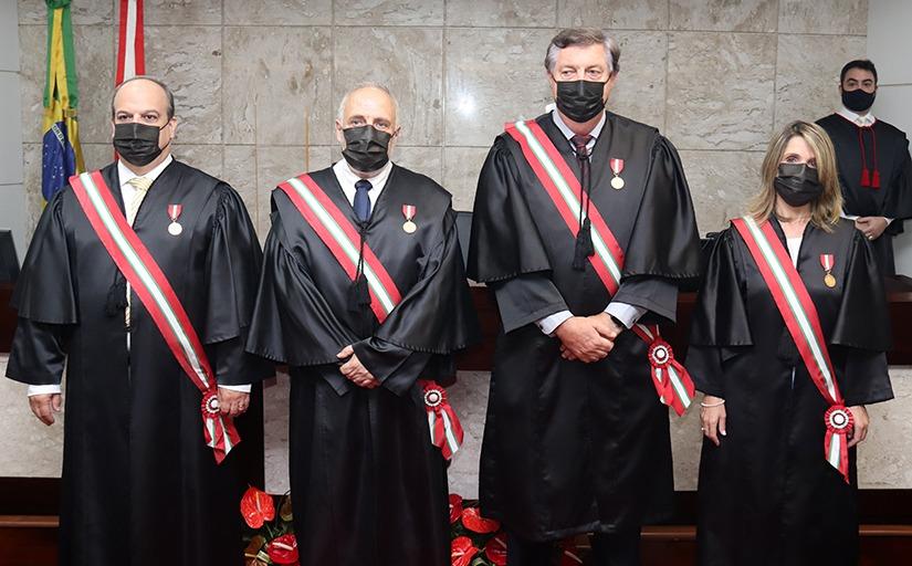 Novos dirigentes do TRT-SC e ouvidora posam para foto oficial, todos de toga e faixa, à frente da mesa do Pleno.