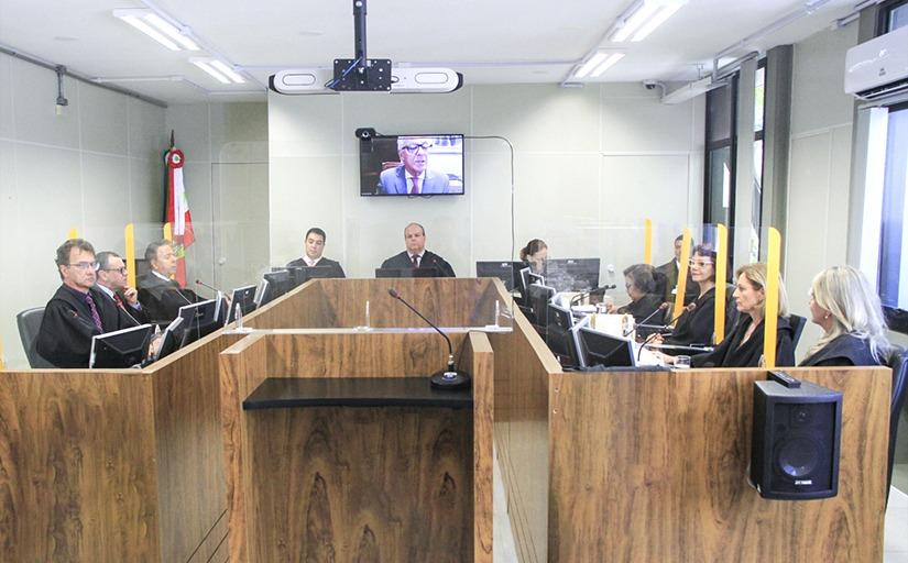 Juízas e juízes sentados, vestindo toga, durante sessão no tribunal