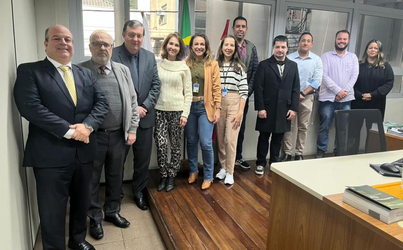 Sete homens e quatro mulheres posam para foto, lado a lado, de pé e sorridentes