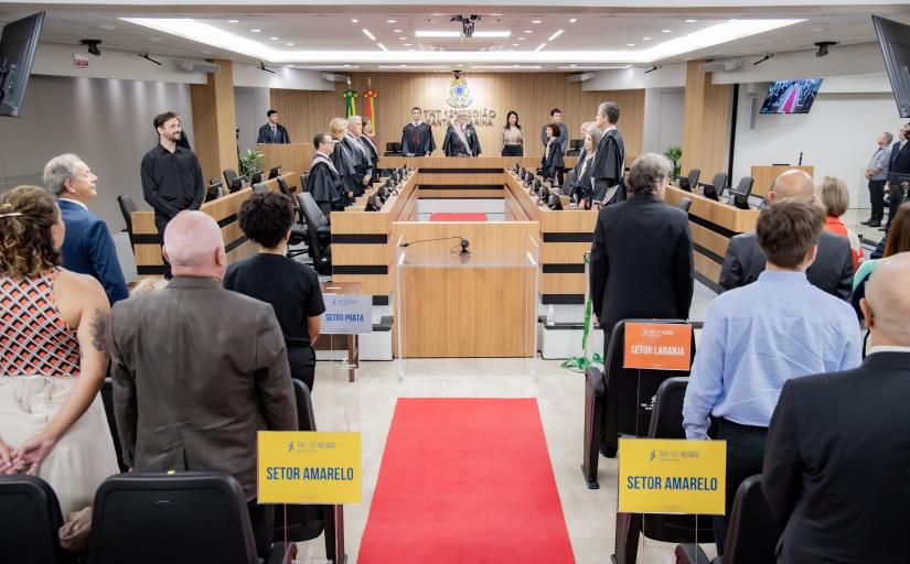 Foto geral do ambiente da sala de sessões do Pleno, com parte do público, os desembargadores e a mesa de honra