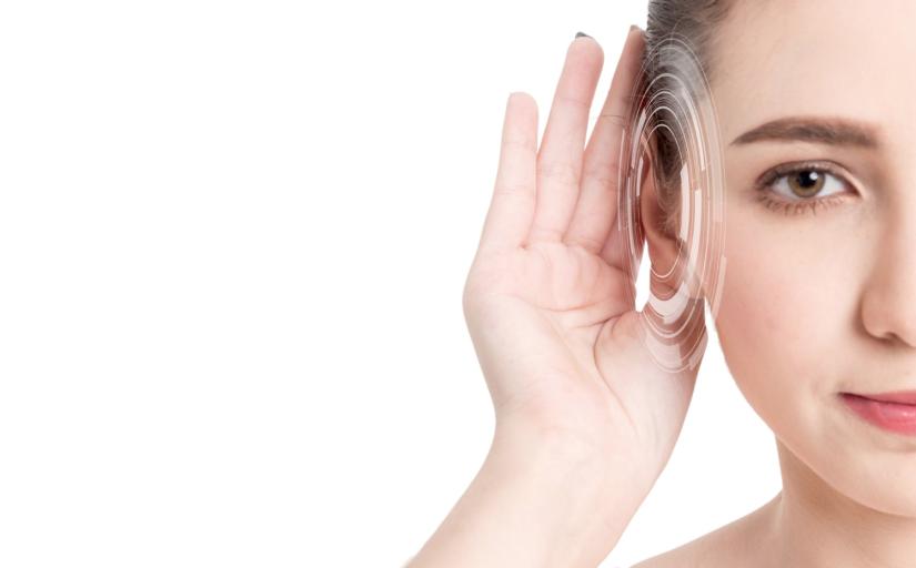 Foto da metade do rosto de uma mulher colocando a mão no ouvido