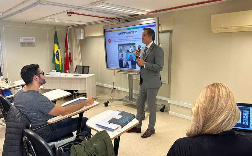 fotografia de um homem branco de terno de pé falando para o público