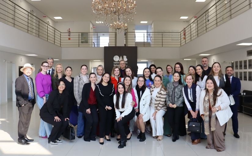 Grupo de diversas pessoas reunidas em um salão branco