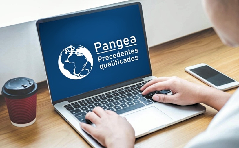 Fotografia de uma pessoa mexendo no notebook. Na tela do aparelho, a logo do Pangea