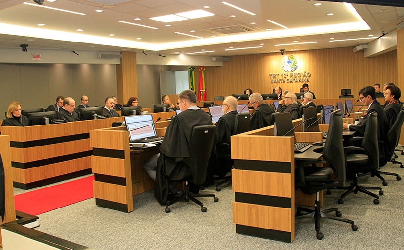 Fotografia da sala de sessões do pleno. Sentados, diante de microfones e telas de computadores, homens e mulheres de toga estão concentrados.