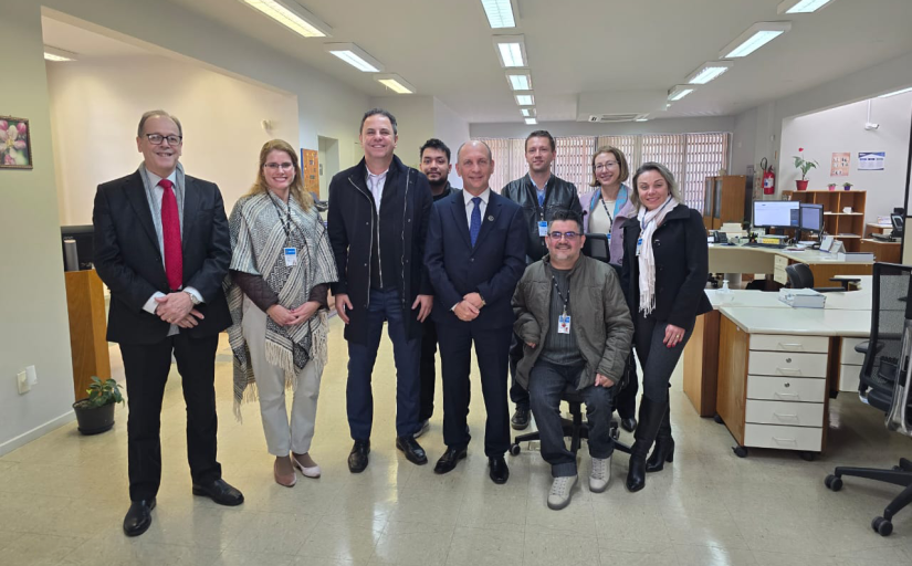 Fotografia de um grupo de nove pessoas, sendo seis homens e três mulheres nas instalações internas da vara do trabalho de Fraiburgo