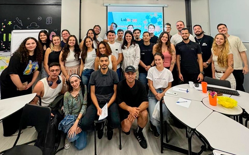 Foto de grupo em sala de aula com cerca de 25 pessoas sorrindo para a câmera